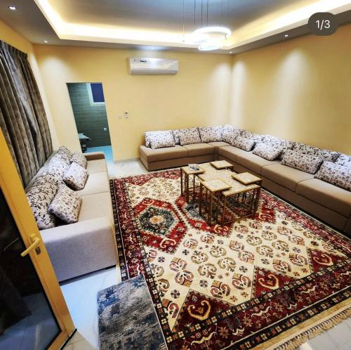 a living room with a couch and a table and a rug at UptownRak FarmHouse in Diqdāqah