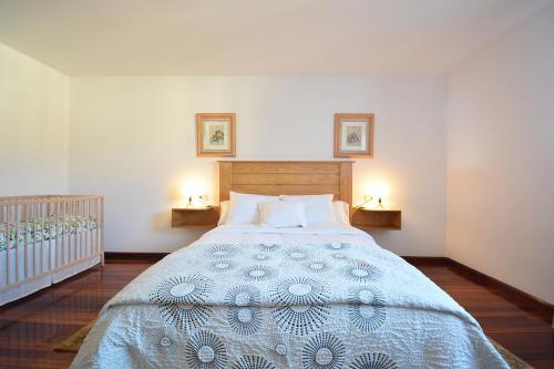 a bedroom with a large bed with two lamps at Casa con jardín en Vilanova de Arousa in Pontevedra