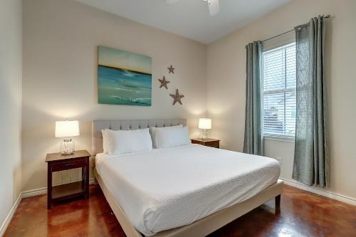 a bedroom with a white bed and two night stands at Anegada Village Dreamcicle in Padre Island
