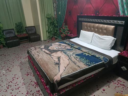 a bed with a painting of a woman on it at New Hajveri Hotel Lahore in Lahore