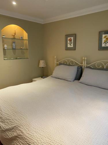 a bedroom with a large white bed with two pillows at Garden Cottage in Great Yarmouth