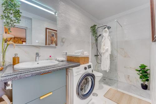 a bathroom with a washing machine and a sink at Lux and Cozy apartment in Los Cristianos
