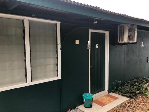 a green house with a door and a window at Rumah Tepi Istana in Kuala Terengganu