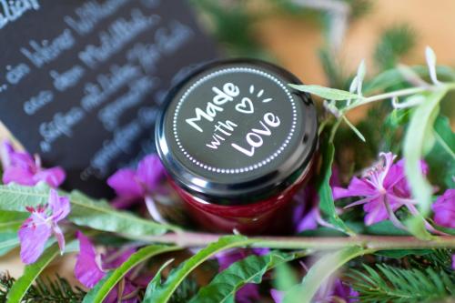 a bottle of jam sitting on some purple flowers at Grogg 608 Apt I I in Martello