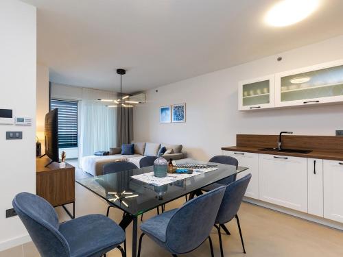 a kitchen and a living room with a table and chairs at Residence Nar in Poreč