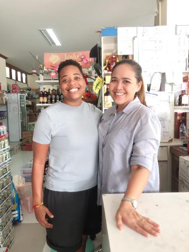 two women standing behind a counter in a store at Baansrisuthum in Don Sak