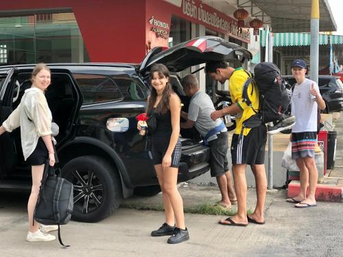a group of people standing around a car with an open trunk at Baansrisuthum in Don Sak