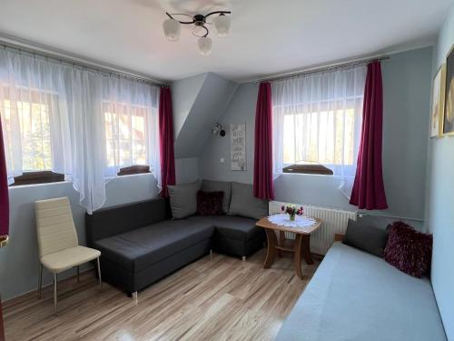 ein Wohnzimmer mit Sofa und Tisch in der Unterkunft Pokoje u Reni - 5 minut do Krupówek - widok na góry in Zakopane