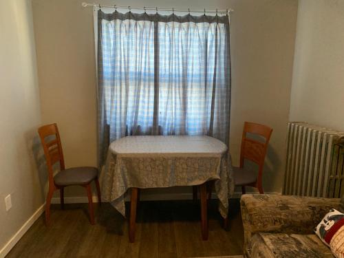 a dining room table with two chairs and a window at Maryland Homestay in Winnpeg downtown in Winnipeg