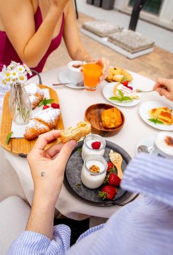 un gruppo di persone seduti a un tavolo con cibo di B&B Domus Mea a Cesenatico