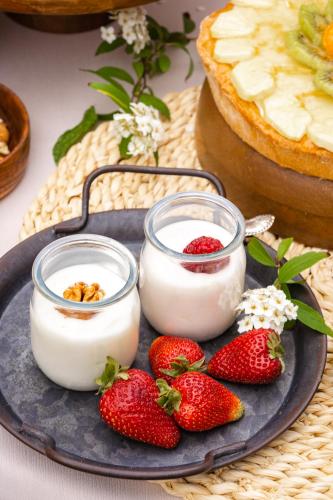 due vasetti di yogurt e fragole su un piatto di B&B Domus Mea a Cesenatico