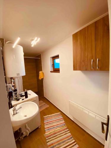 a bathroom with a sink and a toilet and a mirror at Aprócska kulcsosház - Guesthouse in Inlăceni