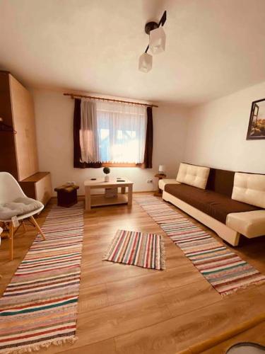 a living room with a couch and a rug at Aprócska kulcsosház - Guesthouse in Inlăceni