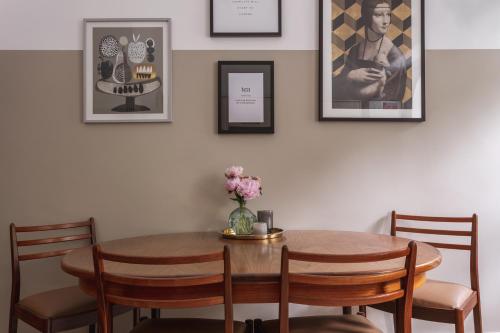 a dining room table with chairs and a vase of flowers at 14 Church Street- close to Windermere Train Station in Windermere