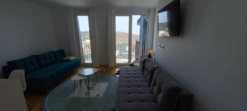 a living room with a couch and a glass table at Apartman GOLD in Bjelašnica