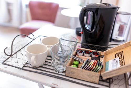 een dienblad met kopjes en een koffiezetapparaat op een tafel bij Bed & Breakfast Rijsterbosch in Rijs