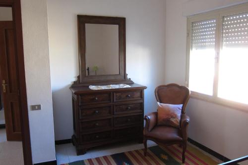 a dresser with a mirror and a chair in a room at La Maddalena spiaggia 80mt dal mare Lido di Capoterra in Capoterra