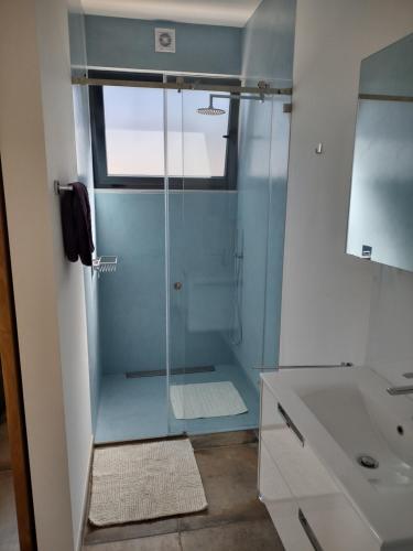 a bathroom with a glass shower and a sink at Suites Sunny hill in Moncarapacho