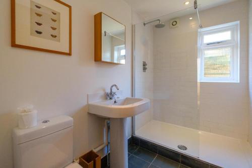 a bathroom with a sink and a shower and a toilet at Lowlands in Thorpeness