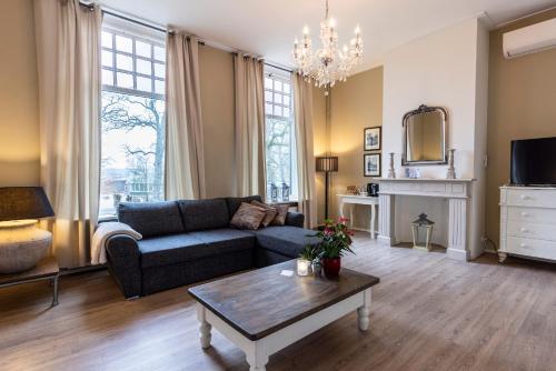 a living room with a couch and a table at Bed & Breakfast Rijsterbosch in Rijs