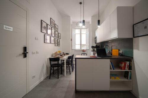 a kitchen with white cabinets and a table with chairs at Veniero37 Guest House in Rome