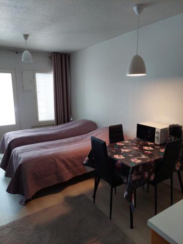 1 dormitorio con 1 cama y 1 mesa con sillas en Kauppala, en Soini