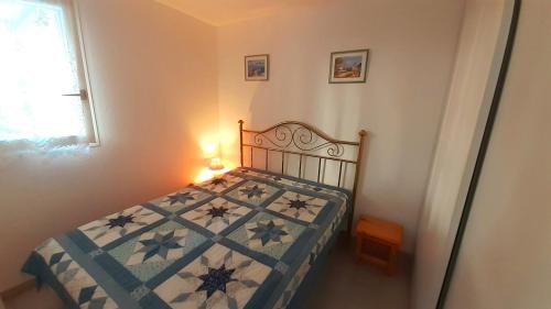 une chambre avec un lit avec une couette dessus dans l'établissement ARCHIPEL III Joli T2 piscine proche plage Richelieu Cap d'Agde, au Cap d'Agde