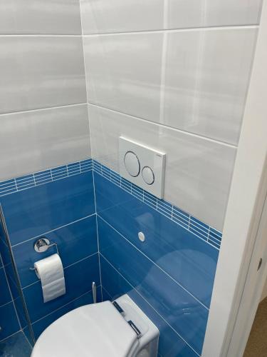 a bathroom with a white toilet and blue tiles at Mare e Sole in Maiori