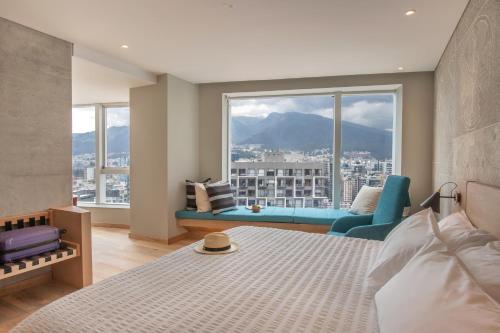 キトにあるGO Quito Hotelのベッドルーム1室(ベッド1台、大きな窓付)
