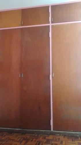 un par de puertas marrones en una habitación en Habitación en LA Urbina, en Caracas