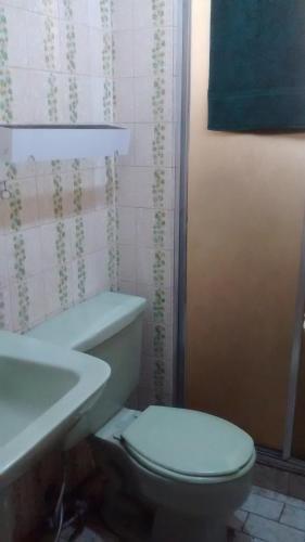 y baño con aseo blanco y lavamanos. en Habitación en LA Urbina, en Caracas