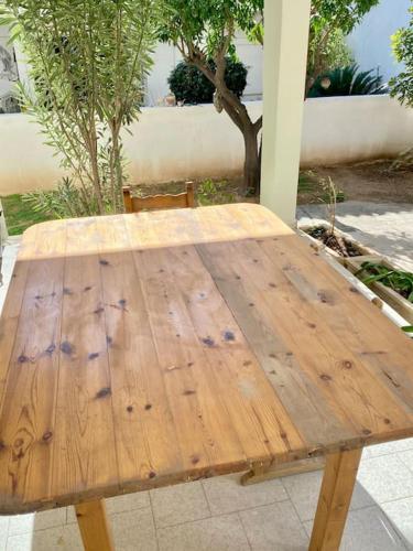 a wooden table with a chair sitting around it at Feels like home (Vari) in Vari