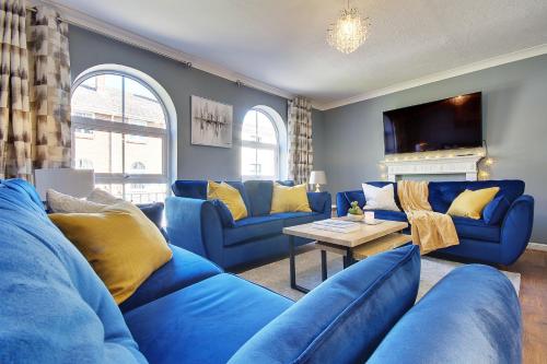 a blue living room with blue couches and a table at 14 Oxford Mews - 5 Star Living for up to 10 People in Southampton