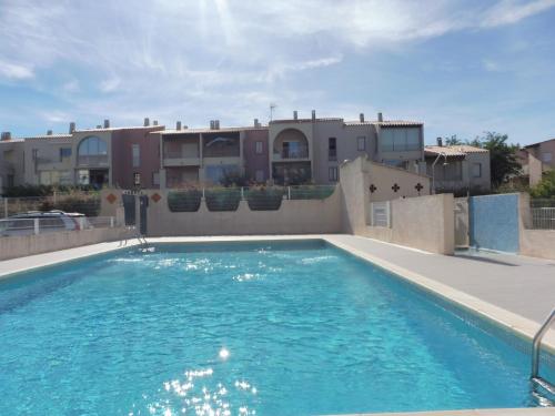 une grande piscine devant une maison dans l'établissement ARCHIPEL III Joli T2 piscine proche plage Richelieu Cap d'Agde, au Cap d'Agde