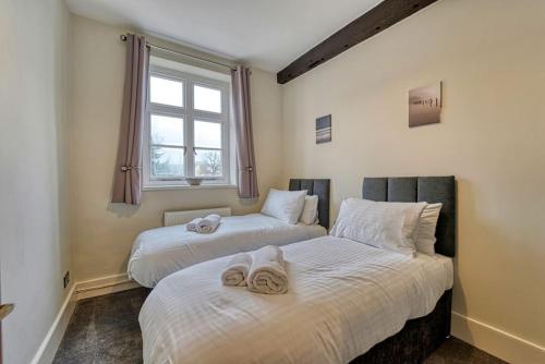 two beds in a room with towels on them at Guest Homes - Harrow Croft Dwelling in Worcester