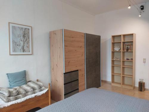 1 dormitorio con 1 cama, armario y silla en Chalet Heiderose SPA - Kamin, Sauna & Wellness en Kluis