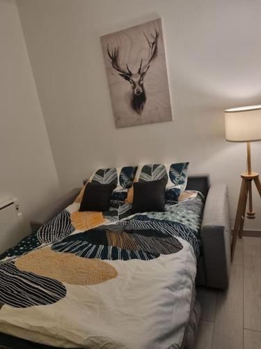 une chambre avec un lit et un tableau de cerf au mur dans l'établissement Joli Studio, à Chaville