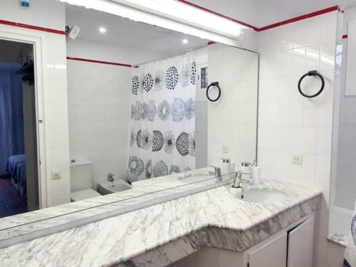 La salle de bains blanche est pourvue d'un lavabo et d'un miroir. dans l'établissement Villa Playa, à L'Ametlla de Mar