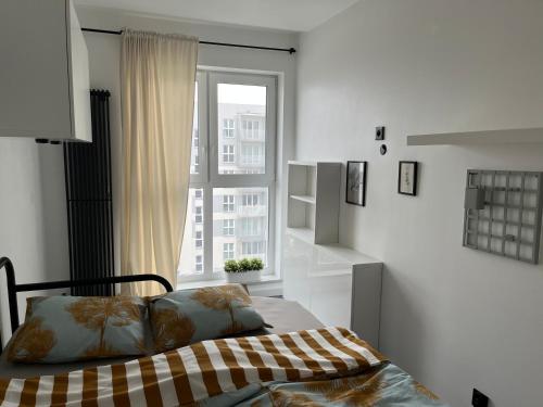 a bedroom with a bed in front of a window at Apartament Bażantów 26 in Katowice
