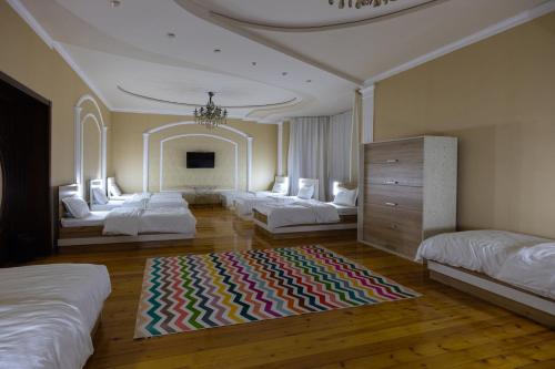 a bedroom with three beds and a rug on the floor at Central Park in Tashkent