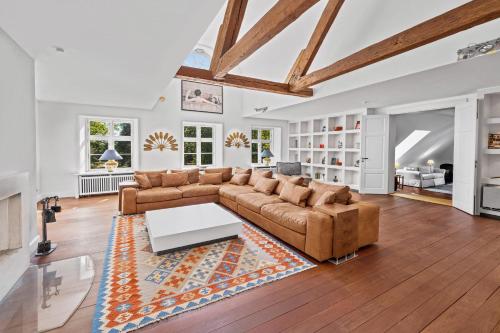 a living room with a couch and a table at GUT KLETKAMP "Penthouse im Schloss" - Premium-Ferienwohnung mit 5 Schlafzimmern auf 400qm I Kamin I 2 Wohnzimmer I Garten & Terrasse I Wald- und Seeblick I Profi-Küche I 15 Min zur Ostsee I Parkplätze I WLAN in Kletkamp