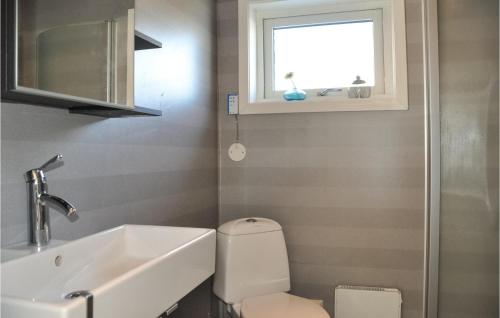 a bathroom with a sink and a toilet and a window at Stunning Home In motfors With Wifi And 2 Bedrooms in Åmotsfors