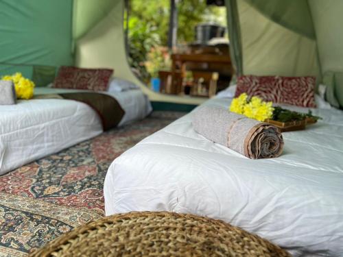 2 Betten in einem Zimmer mit Blumen darauf in der Unterkunft Kejora Homestay in Kangar