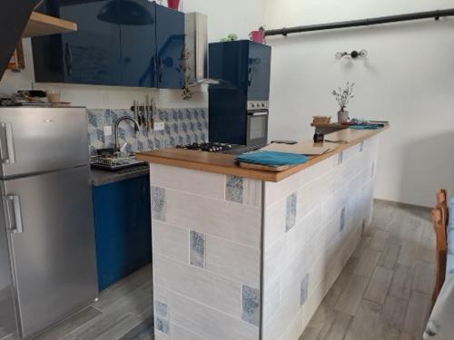 La cuisine est équipée de placards bleus et blancs et d'un réfrigérateur. dans l'établissement Ty-garde, à Peumérit