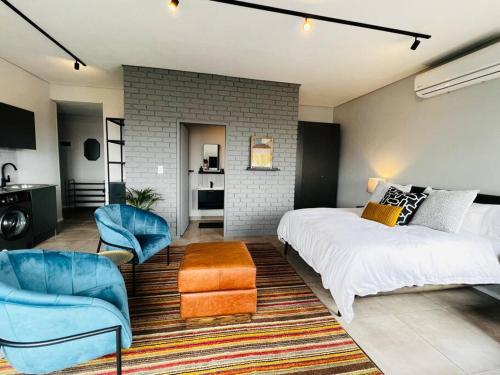 a bedroom with a large bed and a blue chair at Apartment 4023-stunning views in Sandton in Johannesburg