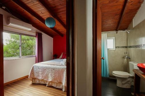 1 dormitorio con cama, aseo y ventana en Elén, en Punta del Diablo