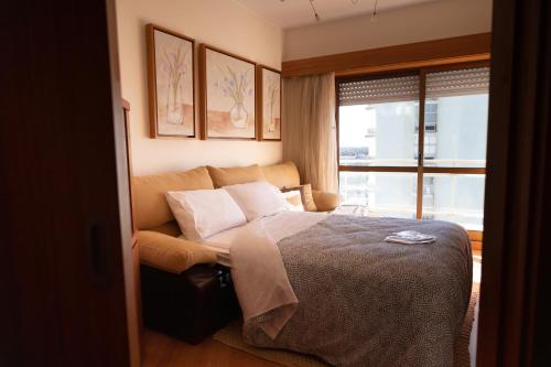 um quarto com uma cama e uma janela em Ofir Beach Flat em Esposende