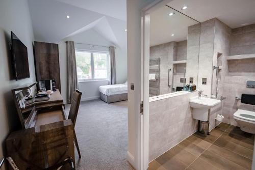 a bathroom with a sink and a toilet and a tub at Shore Hotel Laxey in Laxey