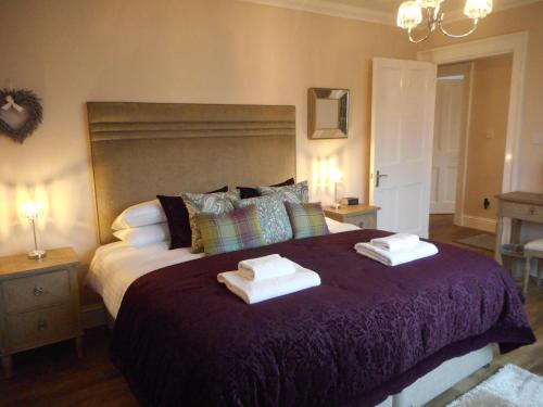 um quarto com uma cama grande com duas toalhas em East Cottage at Parbroath Farm em Cupar
