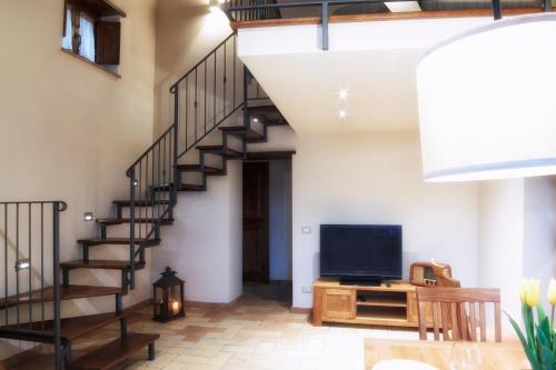 a living room with a staircase and a tv at La Finestra su Civita in Lubriano